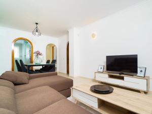 ein Wohnzimmer mit einem Sofa und einem Flachbild-TV in der Unterkunft Apartment Pinazo by Interhome in Cumbre del Sol