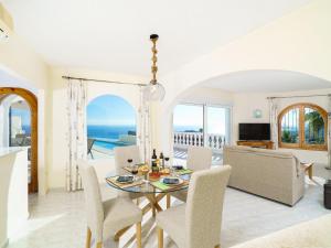 uma sala de jantar com mesa e cadeiras e o oceano em Villa Villa Kalmias by Interhome em Cumbre del Sol