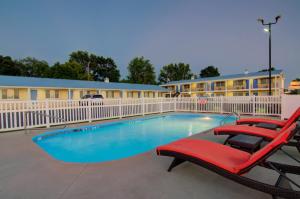 einen Pool mit zwei Liegestühlen und ein Hotel in der Unterkunft Westbridge Inn & Suites in Clinton
