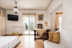 a bedroom with a bed and a table with a couch at Classy lux apt w/ sea view, garden, parking in Corfu