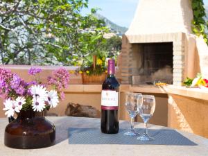 La CanutaにあるApartment Ondina 03のワイングラス2杯付きのテーブルに座ったワイン1本