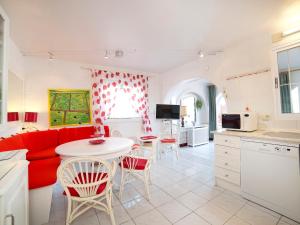 Villa Casa Sanne by Interhome في كاليبي: غرفة معيشة مع أريكة حمراء وطاولة وكراسي