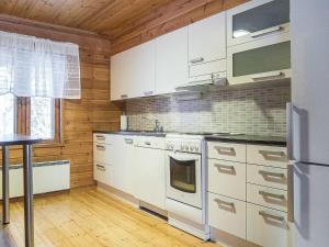 eine Küche mit weißen Geräten und Holzwänden in der Unterkunft Holiday Home Kiehislevi a by Interhome in Levi + 15 Fotos