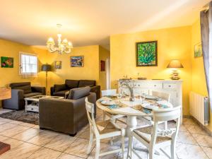 サン・パレ・シュル・メールにあるHoliday Home Les Grillons by Interhomeの黄色の壁のリビングルーム(テーブル、椅子付)
