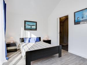 1 dormitorio con 1 cama con almohadas azules en Holiday Home Ty Castero by Interhome, en Quiberon
