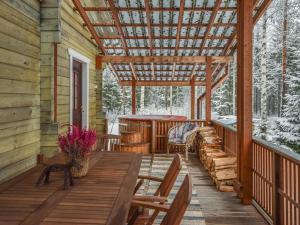 porche de una cabaña de madera con mesa de madera y sillas en Holiday Home Josala by Interhome, en Ruokomäki