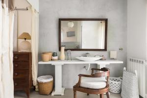 a bathroom with a sink and a mirror and a chair at Classy lux apt w/ sea view, garden, parking in Corfu