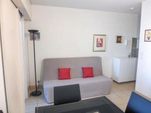 uma sala de estar com um sofá com duas almofadas vermelhas em Studio Le Nadir-3 by Interhome em Fréjus