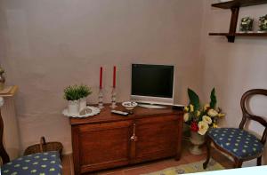 a television on a wooden cabinet with two red candles at Residenza Antico Chianti in Panzano