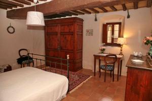 a bedroom with a bed and a desk and a table at Residenza Antico Chianti in Panzano