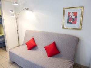 duas almofadas vermelhas num sofá num quarto em Studio Le Nadir-3 by Interhome em Fréjus