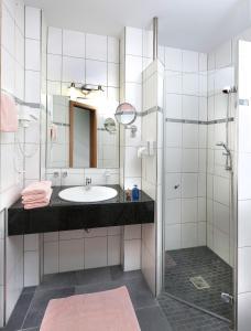 ein Bad mit einem Waschbecken und einer Dusche in der Unterkunft Hotel Pohl in Kinheim