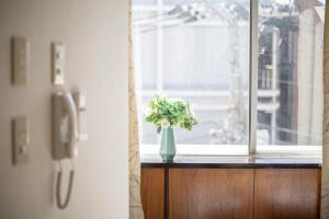 東京にある田端王子ホテルの窓枠に座る花瓶