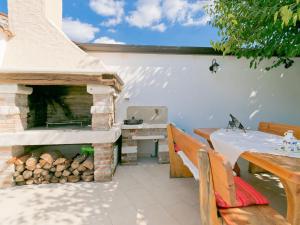 patio z kominkiem, stołem i ławką w obiekcie Holiday Home Darija by Interhome w mieście Villanuova