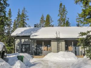 a house covered in snow with a pile of snow at Holiday Home Aihki a by Interhome in Syöte