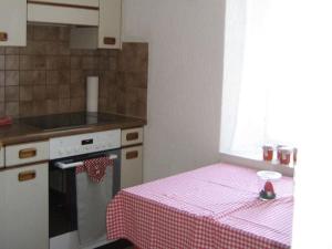 a kitchen with a table with a pink table cloth at Apartment Villa Alpenblick Wolfenschiessen by Interhome in Wolfenschiessen