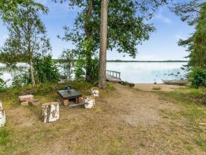 uma mesa de piquenique e um barco na margem de um lago em Holiday Home Rantapirtti by Interhome em Niskamäki