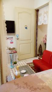 ein Wohnzimmer mit einem roten Stuhl und einer Tür in der Unterkunft Pulisen Homestay in Puli