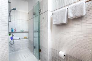 a bathroom with a shower with a glass door at Giorgi's Blue Apartments in Kalathas