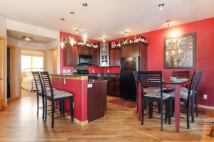a kitchen with red walls and a table and chairs at Nakai Peak 41B Condo in Estes Park