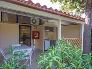 a patio with a table and a kitchen on a house at Holiday Home Gineprino-7 by Interhome in Marina di Bibbona