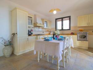 a kitchen with a table with white table cloths on it at Villa Serra by Interhome in Suvereto
