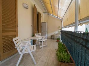 patio z krzesłami i stołem na balkonie w obiekcie Apartment Lungomare by Interhome w Viareggio