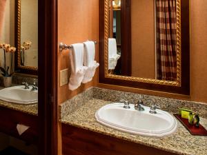 a bathroom with two sinks and a mirror at Olympic Lodge by Ayres in Port Angeles