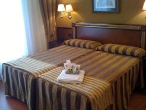 a hotel room with two beds with a tray of food at Hotel Begoña Park in Gijón