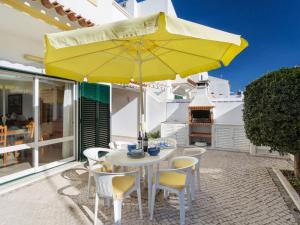 a patio with a white table and yellow umbrella at Holiday Home Manta Rota 450m from the Beach by Interhome in Altura