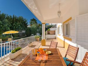 a patio with a wooden table with glasses on it at Villa Natura by Interhome in Guia