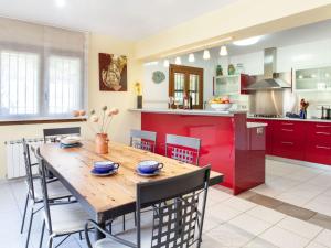 eine Küche mit einem Holztisch und roten Schränken in der Unterkunft Holiday Home Les Agudes by Interhome in Santa Ceclina