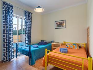 a bedroom with two beds and a window at Holiday Home Grand Beach Hit by Interhome in Pêra