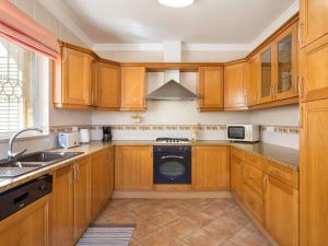 cocina con armarios de madera y lavavajillas en Villa Natura by Interhome, en Guia