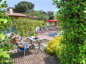 eine Terrasse mit Stühlen und einem Tisch im Garten in der Unterkunft Holiday Home Les Agudes by Interhome in Santa Ceclina