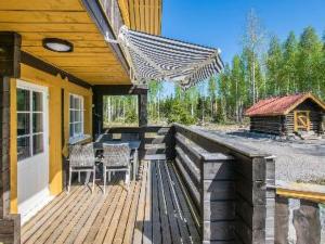 a wooden deck with a table and chairs on a house at Holiday Home Runopuro by Interhome in Kerkonjoensuu