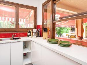 タマリウにあるVilla Chez Noux by Interhomeのキッチン(白いキャビネット、緑の皿が並ぶカウンター付)