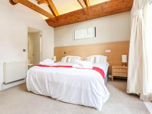 a bedroom with a large bed with white sheets at Holiday Home The Valley by Interhome in Perranwell