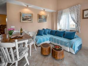 a living room with a blue couch and a table at Holiday Home Villa Aurora in Loborika