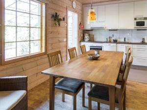 a kitchen with a wooden table and chairs at Holiday Home Villa koira nr2 by Interhome in Vuokatti