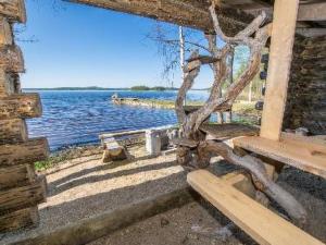 a wooden bench sitting next to a body of water at Holiday Home Runopuro by Interhome in Kerkonjoensuu