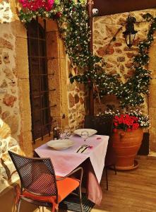 a table with two plates on it in a room with flowers at 24 Seven Boutique Hotel in Malia