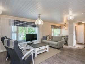 a living room with a couch and a tv at Holiday Home Tähtiranta by Interhome in Valkeala