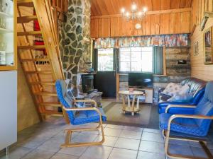 - un salon avec un canapé, des chaises et une cheminée dans l'établissement Holiday Home Kantapää d2 by Interhome, à Luosto