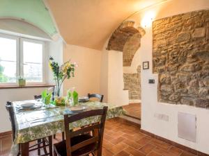 ein Esszimmer mit einem Tisch und einer Steinmauer in der Unterkunft Apartment La Fonte by Interhome in Volterra