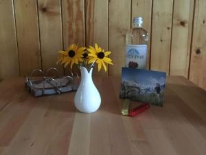 a white vase with flowers and a bottle of water at Apartment Hari by Interhome in Adelboden