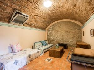 a room with a bed and a couch and a tv at Apartment La Fonte by Interhome in Volterra
