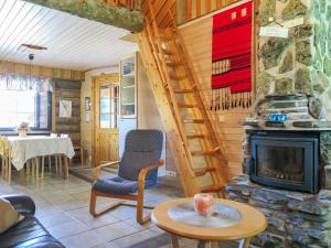 a living room with a fireplace and a staircase at Holiday Home Kantapää d2 by Interhome in Luosto +14 photos