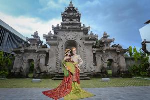a bride and groom posing in front of a building at Anja Jimbaran in Jimbaran