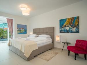 GostinjacにあるHoliday Home Ivana by Interhomeのベッドルーム1室(大型ベッド1台、赤い椅子付)